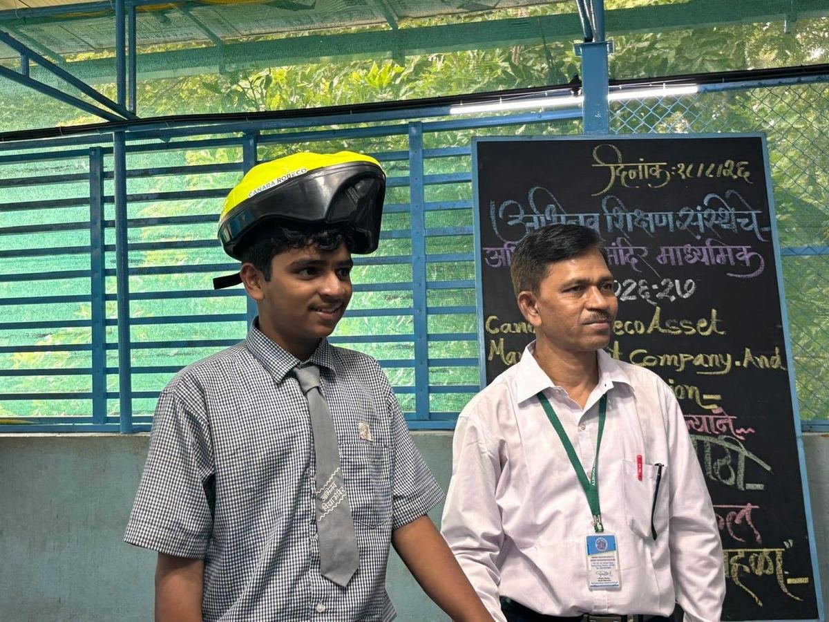 A student tries on his new safety helmet