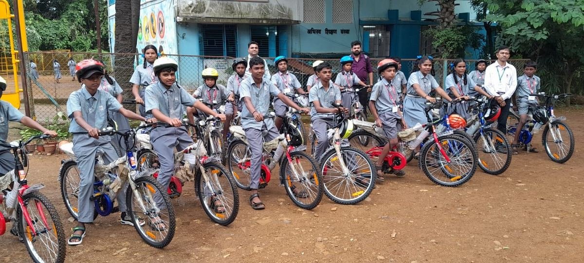 Students with their new bicycles and helmets outside Abhinav Vidya Mandir
