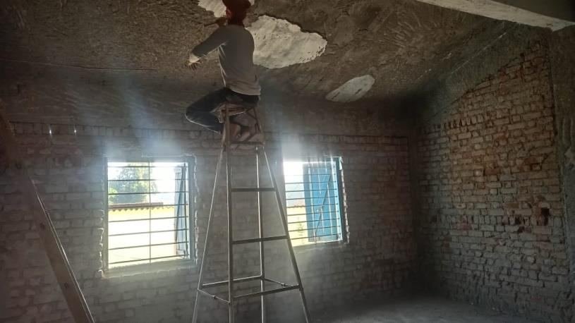 Old plaster being removed inside a classroom