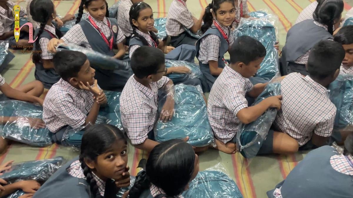 Students with their new bags in the school hall